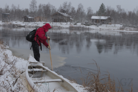 Joen ranta kanootti lumipeitteisen joen rannalla