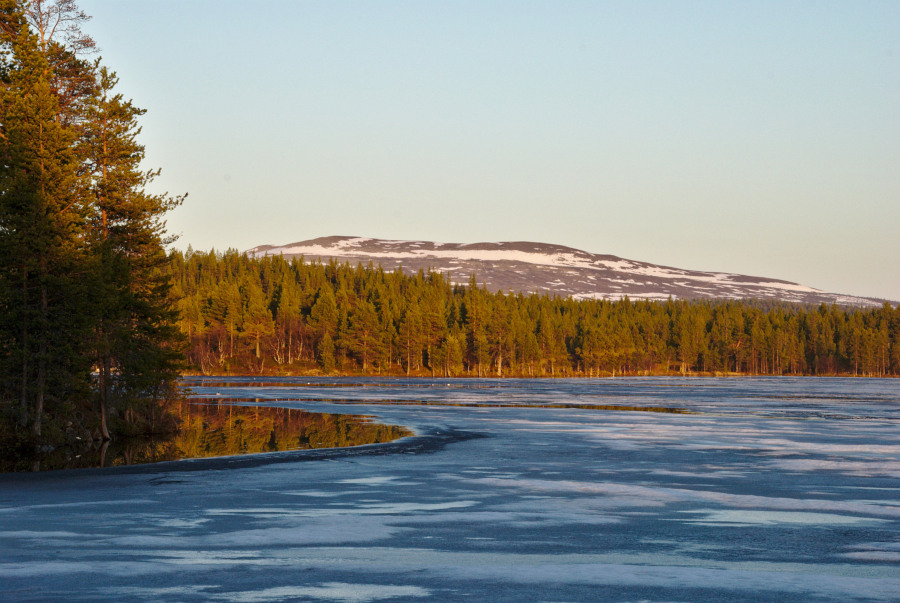 frozen lake with open shore and fell in background